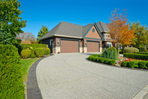 Beautiful concrete driveway leading to the garage of a house.